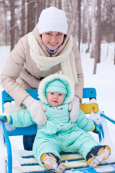 Счастливая семья матери и ребенка в парке зимой — стоковое фото
