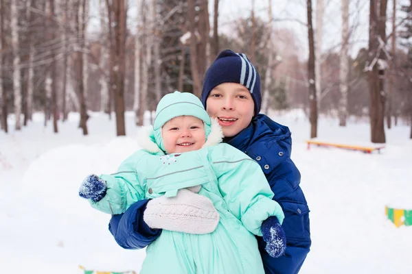 Happy family teenager and baby boy kid in winter park — Stock Photo, Image