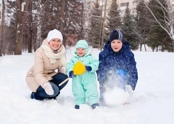 Счастливая семья с ребенком и подростком в зимнем парке — стоковое фото