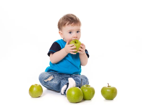 Schattige baby jongen kind eten en spelen met groene appels — Stockfoto