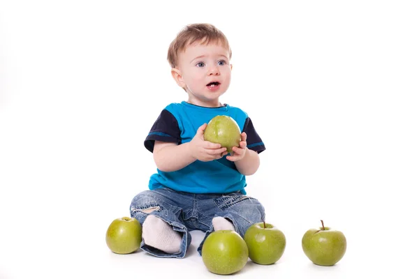 Cute baby boy kid eating and playing with green apples — Stock Photo, Image