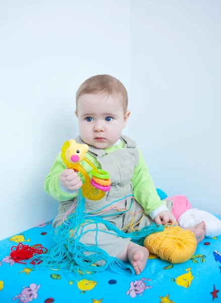 Bambino carino che gioca con il lavoro a maglia — Foto Stock