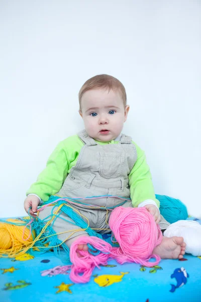 Bebê bonito brincando com tricô — Fotografia de Stock