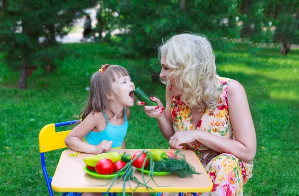 Madre alimentando a su hijo con pepino — Foto de Stock