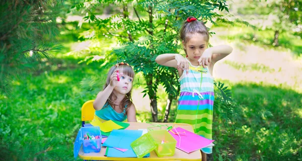 Girls, sisters, kids, friends cutting multicolored paper outdoor — Stock Photo, Image