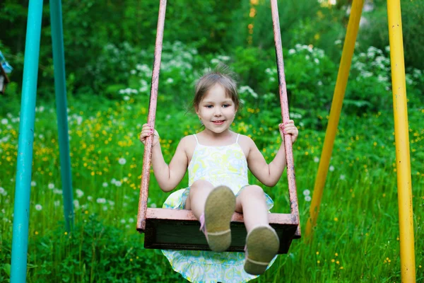 Pequeña chica hermosa balanceándose en el parque — Foto de Stock