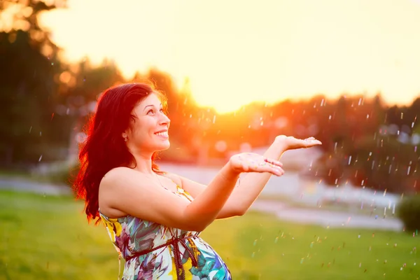 Vacker ung gravid kvinna utomhus med glitter — Stockfoto