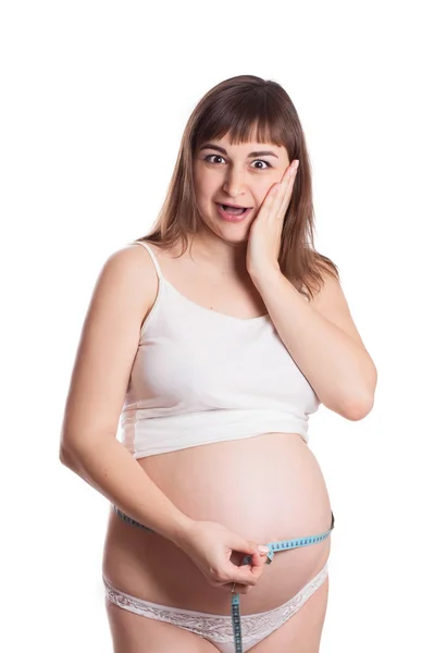 Mulher grávida espantada medindo barriga — Fotografia de Stock