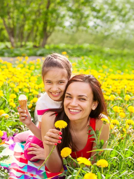 Madre y niño niña niño entre flores amarillas dientes de león — Foto de Stock