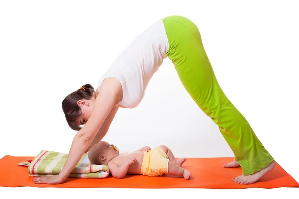 Mujer joven madre practicando yoga con bebé — Foto de Stock