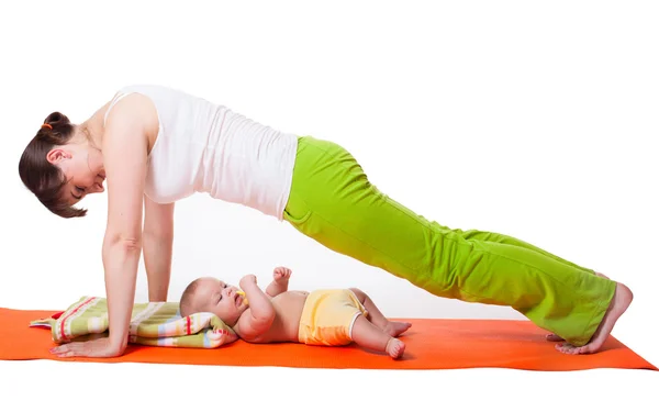 Genç kadın anne bebek ile Yoga uygulamak