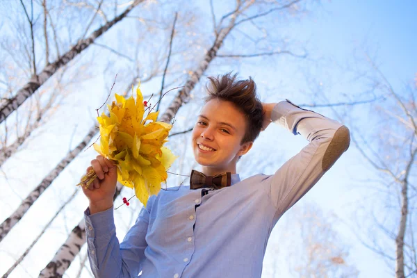Guy holding bouquet of autumn leaves — Stock Photo, Image