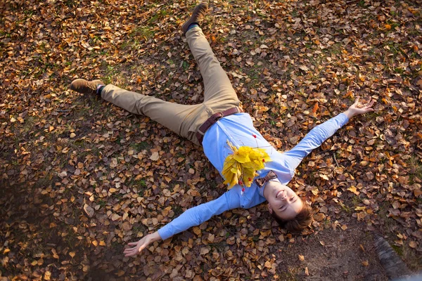 Felice hipster sdraiato nel parco autunnale — Foto Stock