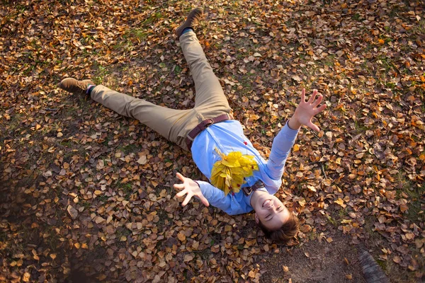 Heureux hipster couché dans le parc d'automne — Photo