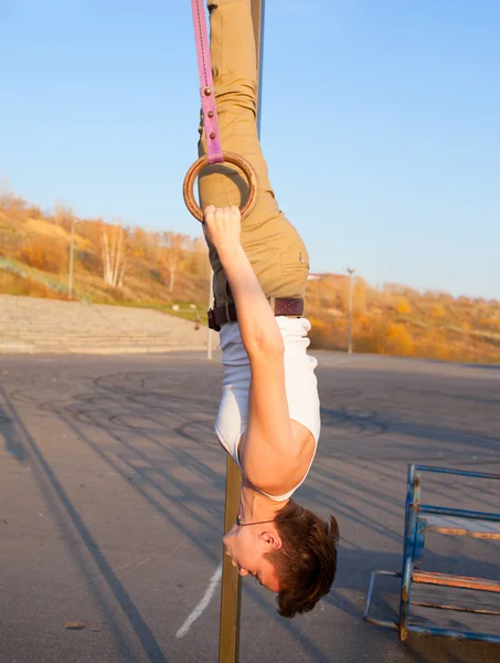 Fille suspendue à l'envers sur des anneaux de gymnastique — Photo