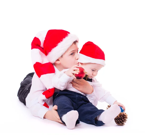 Rapazes irmãos nos chapéus do Pai Natal abraçando — Fotografia de Stock