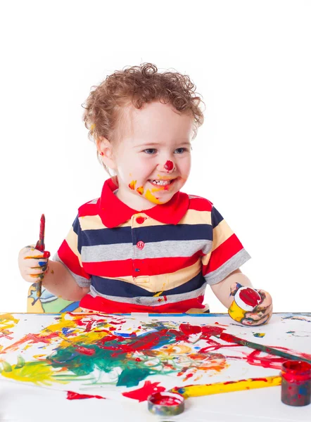 Cute happy baby boy playing with paints — Stock Photo, Image