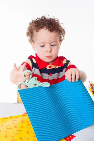 Söta happy baby boy skärande färgglada papper — Stockfoto