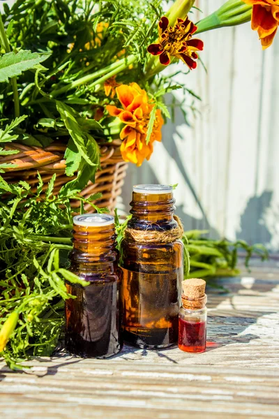 Small bottle of essential marigold oil (Tagetes flowers extract, tincture, infusion) — Stock Photo, Image