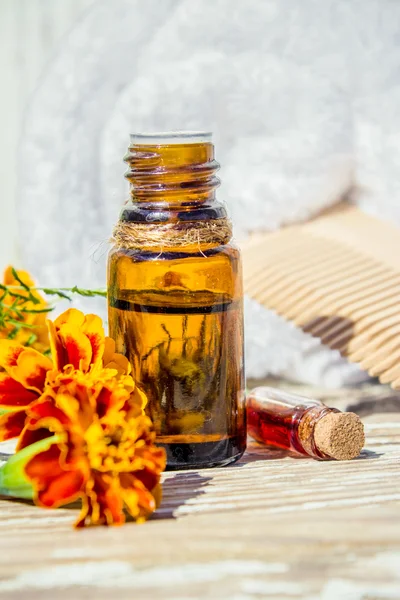 Small bottle of essential marigold oil (Tagetes flowers extract, tincture, infusion) — Stock Photo, Image