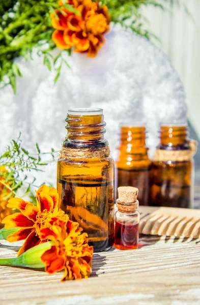 Small bottle of essential marigold oil (Tagetes flowers extract, tincture, infusion) — Stock Photo, Image