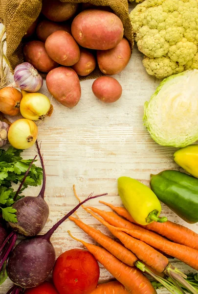 Lebensmittel Rahmen, Markt frische Lebensmittel. sortierte Bio-Gemüse und Gewürze für gesundes Kochen und Lifestyle auf rustikalem Holzhintergrund mit Holzschneidebrett in der Mitte und Kopierplatz für Text — Stockfoto