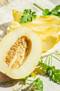 Beyaz ahşap zemin üzerinde sulu olgun sarı kavun.