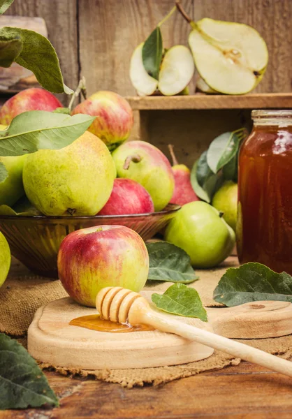 Berair, matang apel dan pir dengan madu di latar belakang kayu . — Stok Foto