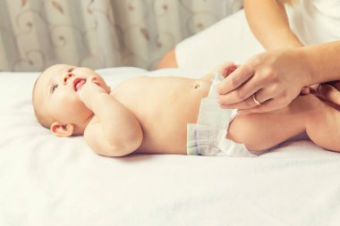 Anne bebeğin bezini değiştiriyor. Seçici odaklanma. İnsanlar.