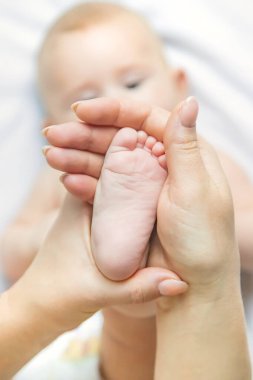 Anne, bebeğin bacağını evde tutuyor. Seçici odaklanma. İnsanlar.