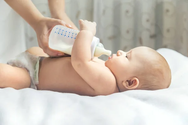 Mãe Alimenta Bebé Com Uma Garrafa Foco Seletivo Pessoas — Fotografia de Stock