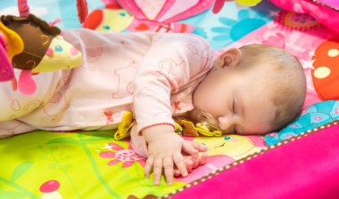 Bebek oyuncaklarla oynamış ve uyuyakalmış. Seçici odaklanma. İnsanlar.