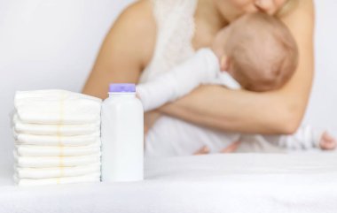 Anne arka planda bebeğin altını değiştiriyor. Seçici odaklanma. insanlar.