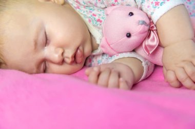 Bebek bir ayıyla uyuyor. Seçici odaklanma. insanlar.