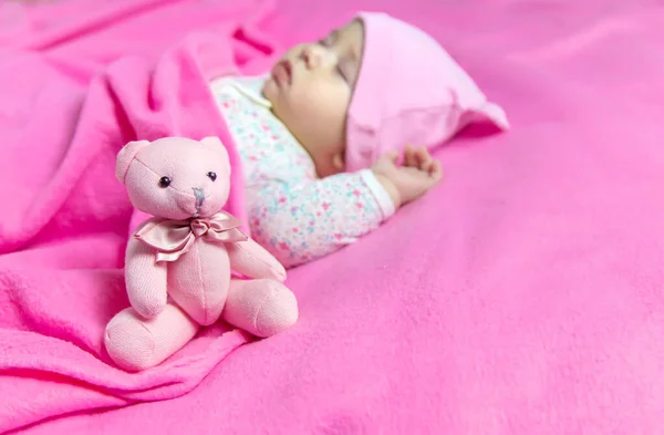 Baby sleeps with a bear. Selective focus. people.