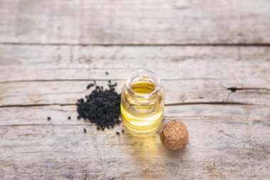Küçük bir şişedeki siyah kimyon yağı. Seçici odaklanma. Doğa.