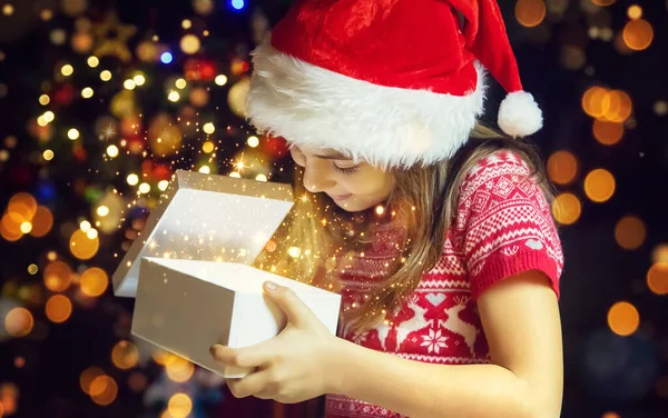 子供はクリスマスツリーの下で贈り物を開きます 選択的フォーカス — ストック写真