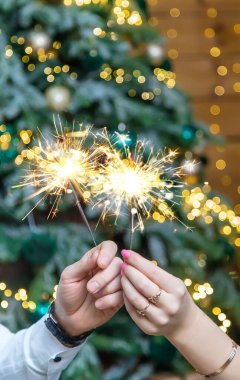 Bengal ışıkları bir erkek ve bir kadının elinde. Seçici odaklanma. Tatil.