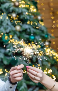 Bengal ışıkları bir erkek ve bir kadının elinde. Seçici odaklanma. Tatil.