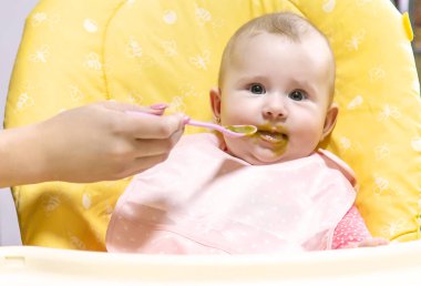 Annem bebeği sebze püresiyle besler. Seçici odaklanma. Yiyecek..