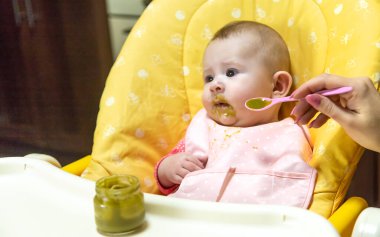 Annem bebeği sebze püresiyle besler. Seçici odaklanma. Yiyecek..