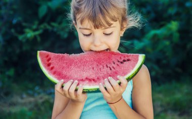 Çocuk yazın karpuz yer. Seçici odaklanma. İnsanlar.