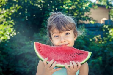 Çocuk yazın karpuz yer. Seçici odaklanma. İnsanlar.