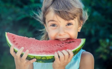 Çocuk yazın karpuz yer. Seçici odaklanma. İnsanlar.