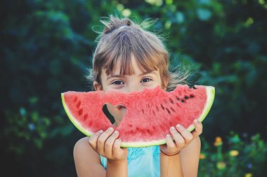 Çocuk yazın karpuz yer. Seçici odaklanma. İnsanlar.