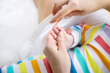 Anne küçük bebeğin tırnaklarını kesiyor. Seçici odaklanma. Çocuk.