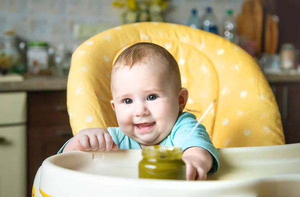Little baby is eating broccoli vegetable puree. Selective focus. people. — Stock Image Little Baby Eating Broccoli Vegetable Puree Selective Focus People Stock Picture