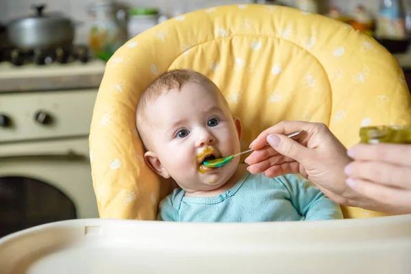 Little baby is eating broccoli vegetable puree. Selective focus. people. — Stock Image Little Baby Eating Broccoli Vegetable Puree Selective Focus People Stock Picture