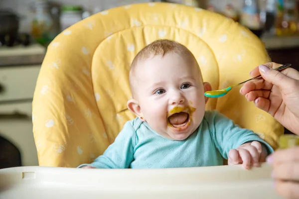 Little baby is eating broccoli vegetable puree. Selective focus. people. — Stock Image Little Baby Eating Broccoli Vegetable Puree Selective Focus People Stock Picture
