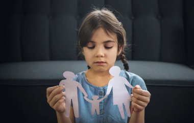 Elinde kağıttan bir aile olan bir çocuk. Boşanma, velayet ve çocuk istismarı kavramı. Seçici odaklanma. İnsanlar.